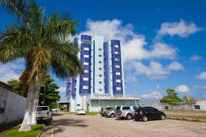 a large blue building with cars parked in a parking lot at GOLD MARTAN HOTEL in Belém