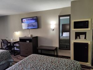 a hotel room with a bed and a desk and a tv at Days Inn by Wyndham Southaven MS in Southaven