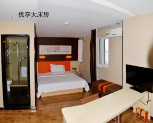 a bedroom with a bed and a tv in a room at 7Days Premium Panjin Oilfield Bus Terminal in Panjin