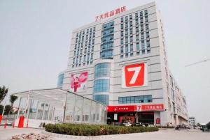 een groot gebouw met een bord ervoor bij 7 Days Premium Dezhou Pingyuan Xinhua Road in Dezhou