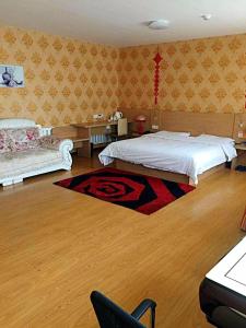 a bedroom with a bed and a table and a couch at 7Days Inn Jixian County Road in Shuangyashan