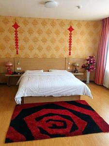 a bedroom with a bed with a rug on the floor at 7Days Inn Jixian County Road in Shuangyashan