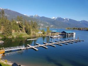 a dock on a lake with mountains in the background at Kaslo Bay Condominium in Kaslo