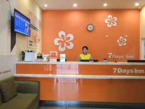 une femme qui se tient au guichet d'un magasin dans l'établissement 7Days Inn Weinan Jiefang Road railway station, à Weinan