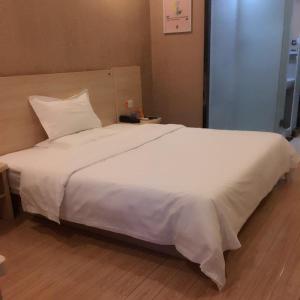 a large white bed in a hotel room at 7Days Inn Dongtai Hong Lan Road RT-Mart in Dongtai