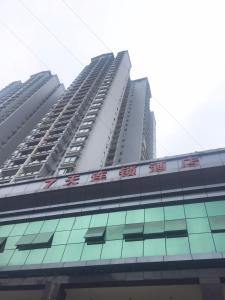 ein hohes Gebäude mit chinesischer Schrift auf der Seite in der Unterkunft 7Days Inn Chongqing Penghu Pengshui Garden in Pengshui