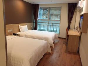 a hotel room with two beds and a window at 7Days Inn Chongqing Penghu Pengshui Garden in Pengshui