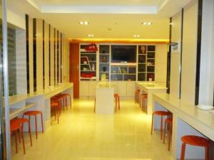 una cucina con un mucchio di tavoli e sedie di 7Days Premium Chongqing Fengjie Kuizhou Avenue a Fengjie