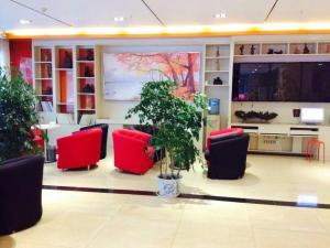 - un hall avec des chaises rouges et une grande télévision dans l'établissement 7Days Premium Chongqing Fengjie Kuizhou Avenue, à Fengjie