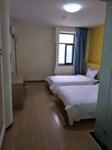 a hotel room with two beds and a window at 7Days Inn Nanjing South Railway Station Jiangjun Avenue in Nanjing