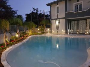 una piscina frente a una casa por la noche en Villa Joel, en Fontane Bianche