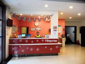 a man standing behind a counter in a store at 7Days Inn Tianjin Zhongshan Road North Station in Tianjin