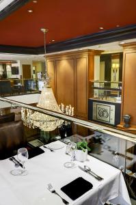 a dining room with a table and a chandelier at Hôtel Le Cantlie Suites in Montréal