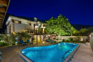 una casa con piscina por la noche en Palazzo Banicevic Luxury Rooms en Kotor