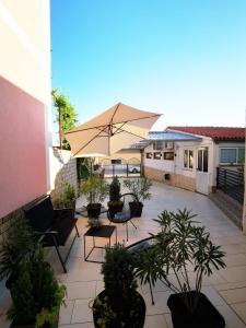a patio with chairs and an umbrella and plants at Apartment Dante in Fažana