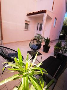a patio with chairs and plants in front of a building at Apartment Dante in Fažana