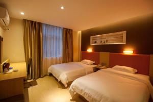 a hotel room with two beds and a window at 7Days Premium Zhuzhou Yangtze River Road Central Hospital in Zhuzhou