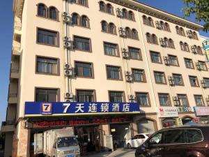 a building with a blue sign in front of it at 7Days Inn Huaian vehicle administration in Huai'an