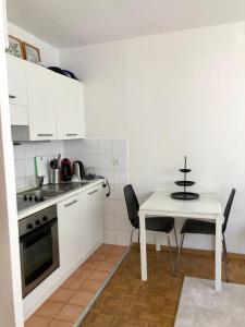 a kitchen with white cabinets and a table and chairs at The Paquis Oasis in Central Geneva in Geneva