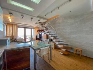 a kitchen with a spiral staircase in a room at Уютный дом на первой линии моря in Chornomorsk