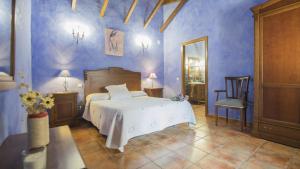 a bedroom with a bed and a blue wall at Los Laureles 2 in Urda