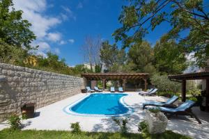 a swimming pool in a backyard with a stone wall at Palazzo Banicevic Luxury Rooms in Kotor
