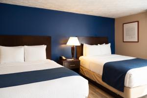 two beds in a hotel room with blue walls at Hotel Pentagon in Arlington