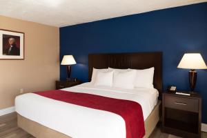 a bedroom with a large bed with a blue wall at Hotel Pentagon in Arlington