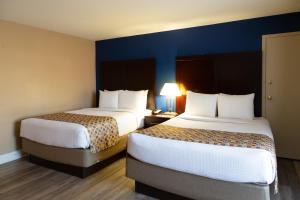 two beds in a hotel room with blue walls at Hotel Pentagon in Arlington