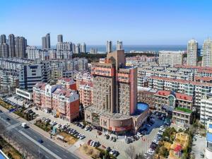 una vista aerea di una grande città con edifici di 7Days Premium Weihai High-speed Rail Station Bathing Beach a Weihai