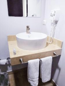 a bathroom with a sink with towels hanging from it at Sleep Inn Hermosillo in Hermosillo