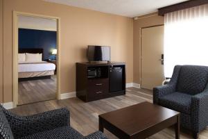 a hotel room with a room with a bed and a living room at Hotel Pentagon in Arlington