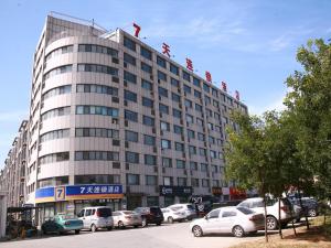 a large building with cars parked in a parking lot at 7Days Inn Zibo Dongsi Road Shengshi Xincheng in Zibo