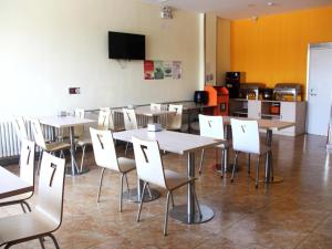 comedor con mesas y sillas y TV en 7Days Inn Rizhao Development Zone, en Rizhao