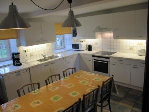a kitchen with a table and chairs and white cabinets at Theux - La Reid in Theux