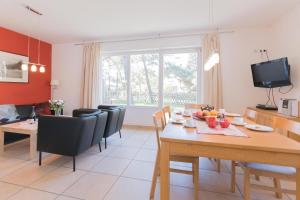 a kitchen and dining room with a table and chairs at STRANDHAUS 43 in Dierhagen