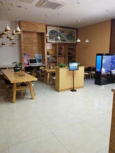 Großes Zimmer mit Tischen und einem TV. in der Unterkunft 7Days Premium Wangcheng Walking Street in Changsha