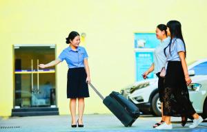 two women walking down a street with a suitcase at 7Days Inn Ankang Ba Shandong Road Anyunsi in Ankang