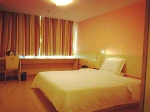 een hotelkamer met een wit bed en een raam bij 7Days Inn Yulin south gate bus station in Yulin