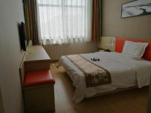 een slaapkamer met een groot bed en een rode stoel bij 7Days Inn Yulin south gate bus station in Yulin