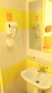 W łazience znajduje się umywalka i lustro. w obiekcie 7Days Inn Langzhong Seven Mile Avenue w mieście Langzhong