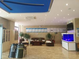 - un hall avec une télévision et des canapés dans l'établissement 7Days Inn Aksu Airport, à Wensu