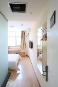 - une chambre avec un lit et une chambre avec un miroir dans l'établissement 7Days Inn Baoding Quyang Taihang Road Bus Terminal, à Quyang