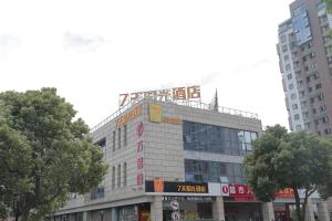 un edificio con un cartel en la parte superior en 7Days Inn Suzhou Industrial Park Sheng Pu Tongjiang Road, en Suzhou