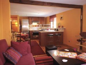 a living room with a couch and a kitchen at La Maison Bleue in Kientzheim