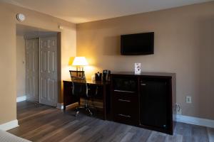 a hotel room with a desk and a television on the wall at Hotel Pentagon in Arlington