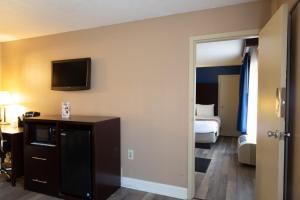 a hotel room with a bed and a television on the wall at Hotel Pentagon in Arlington
