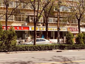 石家荘市にある7Days Inn 261 Shijiazhuang Zhonghua Street New Railway Stationの建物前に駐車した白車
