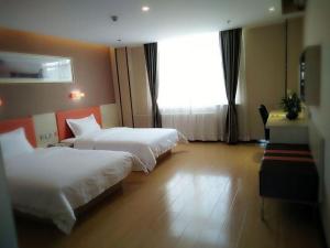 Shizuishanにある7Days Premium Shizuishan Dawukouのベッド2台と窓が備わるホテルルームです。