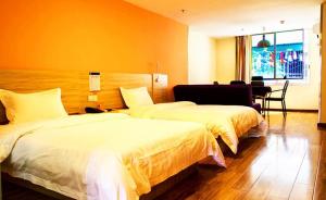 ein Hotelzimmer mit 2 Betten und einem Schreibtisch in der Unterkunft 7Days Inn Chongqing Yunyang passenger terminal station in Shuangjiang